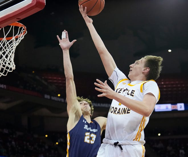 Kettle Moraine's Jack McSorley (1) scores as Marquette's Nolan Minessale (23) attempts to block the shot during the first half of the WIAA Division 1 boys basketball state semifinal game on Friday March 15, 2024 at the Kohl Center in Madison, Wis.