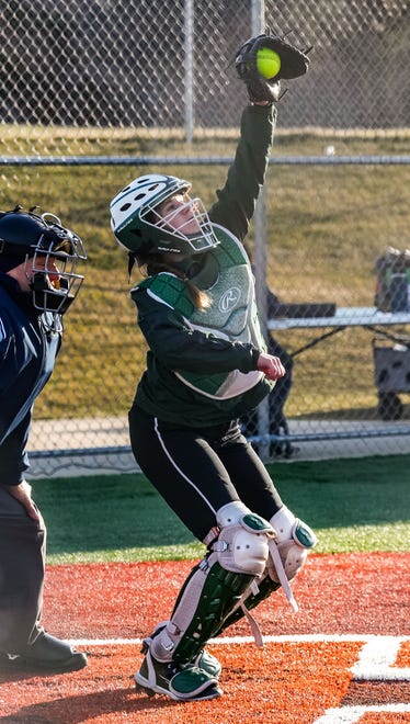 Wauwatosa West catcher Kate Koenigs (12) pulls in a high pitch during the game at home against Wauwatosa East, Thursday, March 21, 2024.